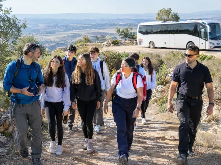 מדריך טיולים, חובש ומאבטח מלווים קבוצת תלמידים בטיול